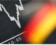 A German flag of a trader supporting the German national football team hangs in front of a board displaying Germany's share index DAX on June 18, 2012 at the stock exchange in Frankfurt/M., western Germany. German stocks opened 1.21 percent higher as investors cheered a weekend election victory for Greece's main pro-bailout party, easing fears Athens may drop out of the eurozone. AFP PHOTO / DANIEL ROLAND        (Photo credit should read DANIEL ROLAND/AFP/GettyImages)