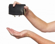 close-up of a woman's hands turning purse upside down