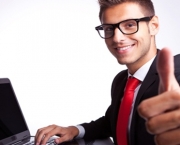 side view of a business man working on laptop and making the ok gesture